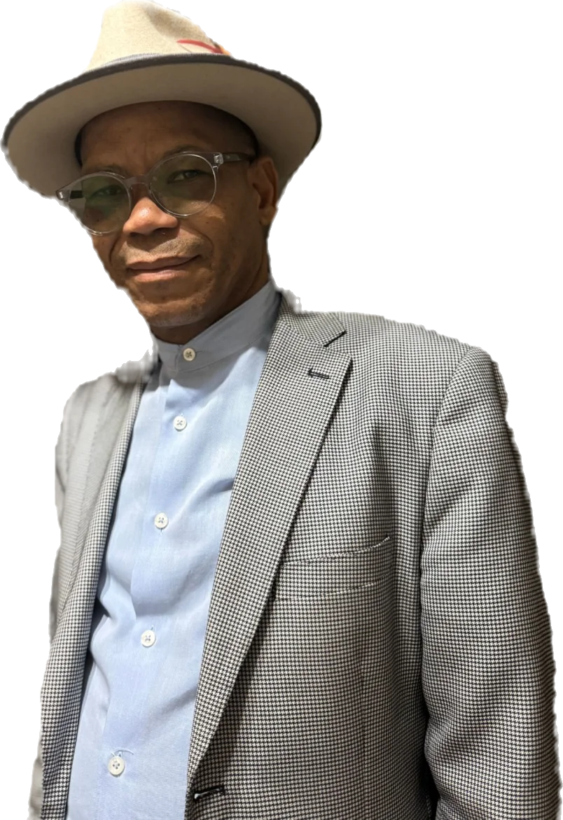 Portrait of China Mashinini wearing a fedora and houndstooth blazer